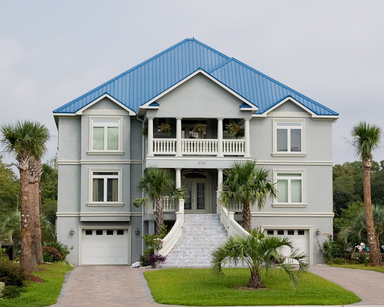 Large coastal home with blue metal roof