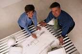 Two professionals examining architectural blueprints
